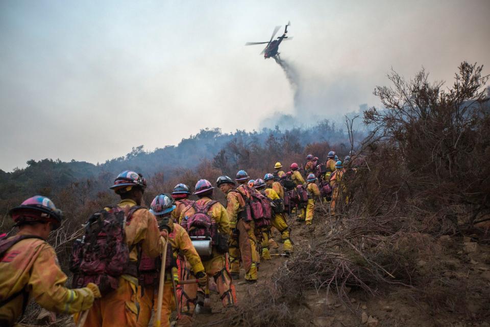 <p>A firefighting helicopter drops water makes a water drop near the Cal Fire CCC Fire Crew from Camarillo Fire Center during the Holy Fire in Lake Elsinore, Calif., Aug. 10, 2018. (Photo: David McNew/EPA-EFE/REX/Shutterstock) </p>