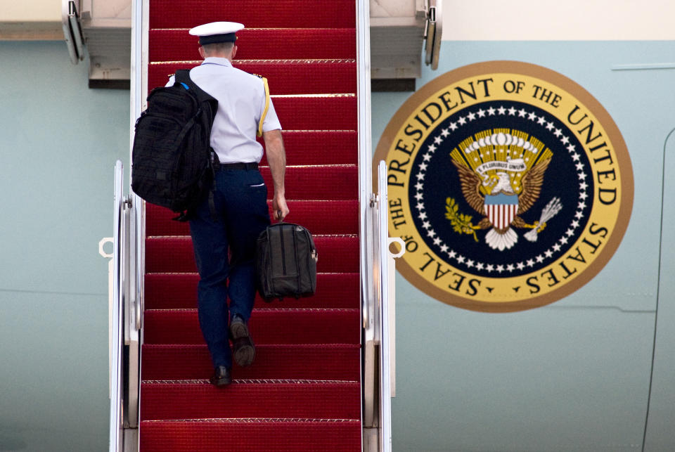 A military aide carries the Presidential Emergency Satchel in his right hand as he walks up the stairs of Air Force One at Andrews Air Force Base, Md., on Wednesday, April 7, 2010, as President Barack Obama prepared to depart for Prague. (AP Photo/Cliff Owen, File)