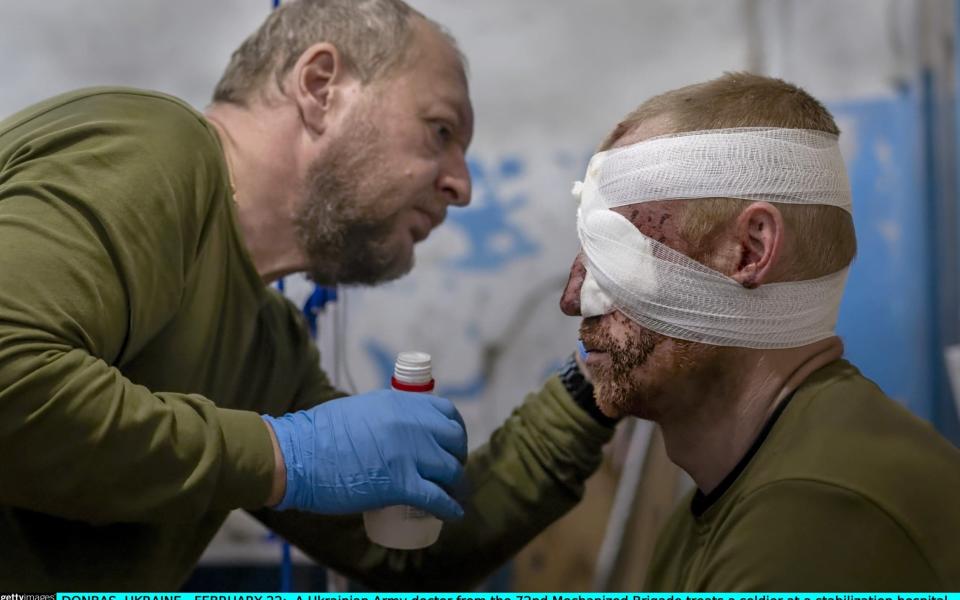  Ukrainian Army doctor from the 72nd Mechanized Brigade treats a soldier at a stabilization hospital near the frontline on February 22, 2023 in the Donbas region of eastern Ukraine - John Moore