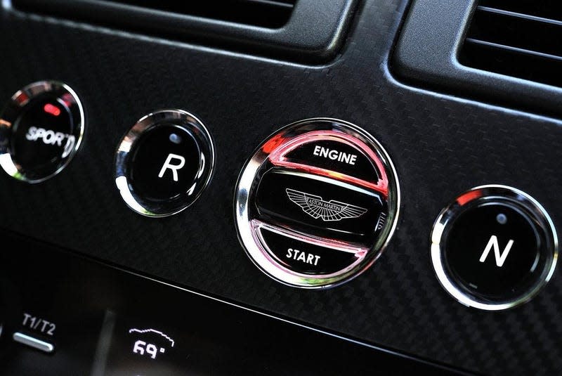 A photo of the Aston Martin key in the dashboard. The Aston Martin emblem sits flush in the dash when it's on.