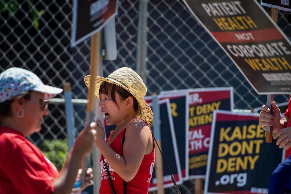 Sophia Mendoza, center, secretary-treasurer of the National Union of Healthcare Workers, calls out chants using a megaphone during strike involving mental health clinicians on Monday, Aug. 15, 2022, at Kaiser Permanente Sacramento Medical Center and Medical Offices on Morse Avenue in Arden Arcade.