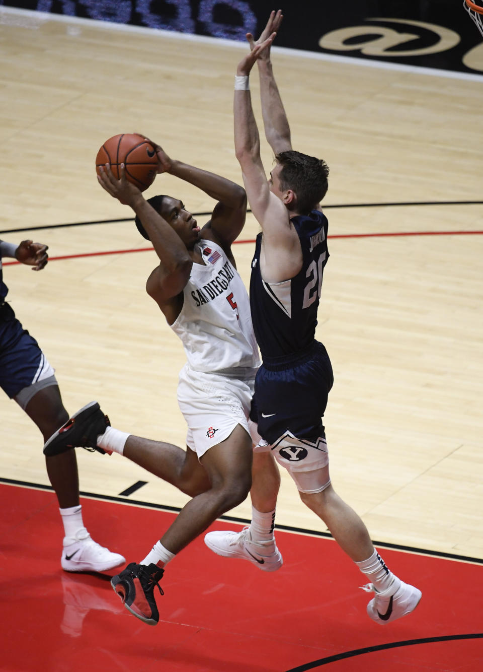 San Diego State guard Lamont Butler (5) tries to shoot over BYU guard Spencer Johnson (20) during the first half of an NCAA college basketball game Friday, Dec. 18, 2020, in San Diego. (AP Photo/Denis Poroy)