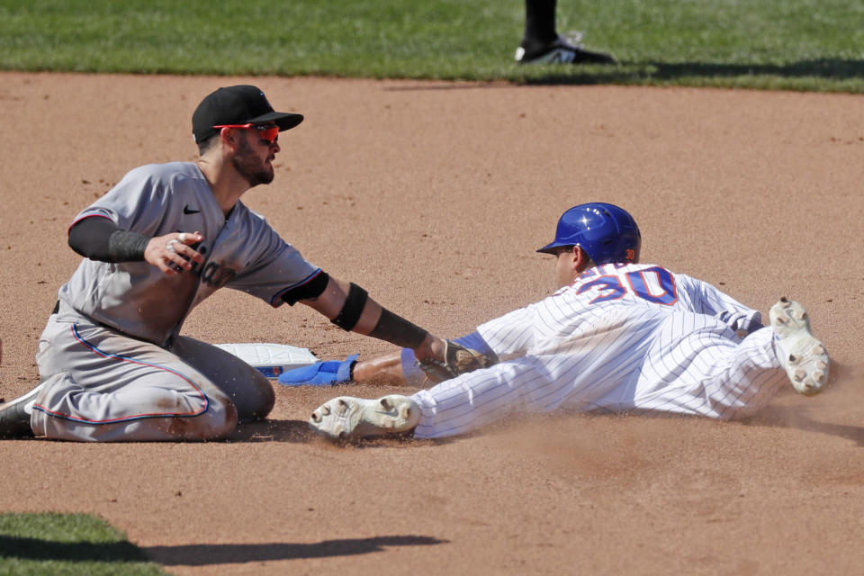 Miami Marlins second baseman Eddy Alvarez, left, tags out New York Mets' Michael Conforto (30) stealing second during the seventh inning of a baseball game at Citi Field, Sunday, Aug. 9, 2020, in New York. The Marlins challenged the call on the field and it was overturned in the challenge. (AP Photo/Kathy Willens)