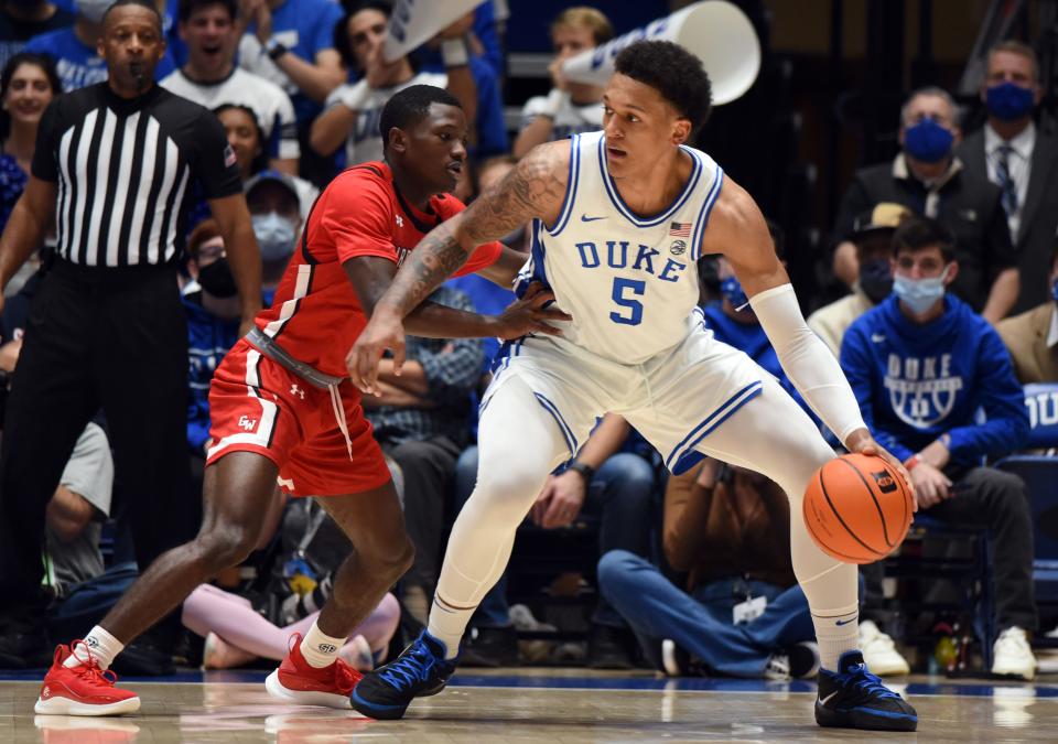 Nov 16, 2021; Durham, North Carolina, USA;  Duke Blue Devils forward Paolo Banchero (5) controls the ball in front of Gardner-Webb Runnin' Bulldogs guard Julien Soumaoro (1) during the first half at Cameron Indoor Stadium. Mandatory Credit: Rob Kinnan-USA TODAY Sports