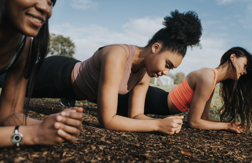 three women plank in the sun