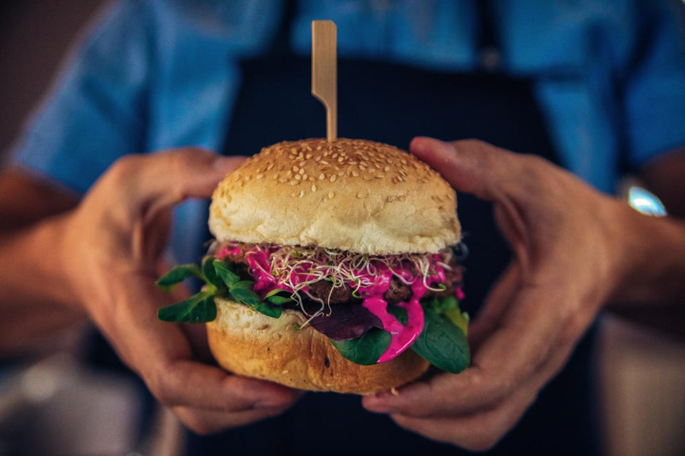 A man holds a veggie burger.