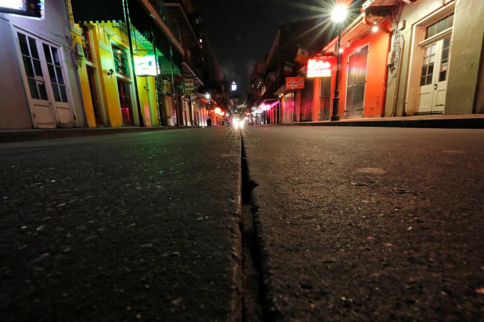 In this Thursday, March 19, 2020, file photo, a view of the nearly deserted scene on Bourbon Street, which is normally bustling with tourists and revelers, in the French Quarter of New Orleans. Like many cities around the country, New Orleans is currently under a shelter-in-place order as it grapples with a growing number of coronavirus cases.