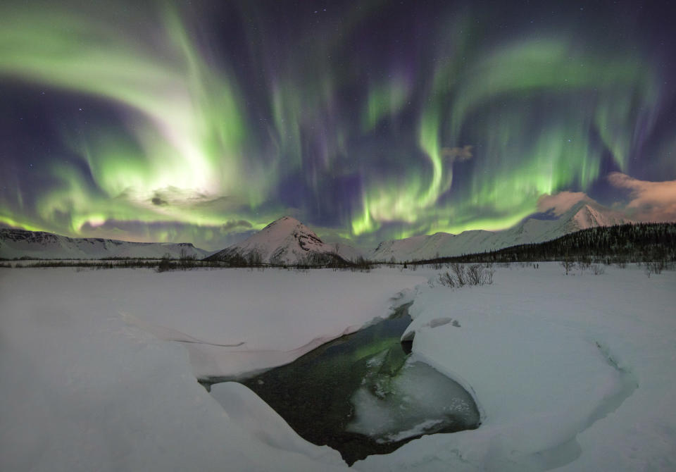 <p>These Northern Lights “rainbows” have turned the sky greener than the Earth below. (Photo: Vitaly Istomin/Caters News) </p>