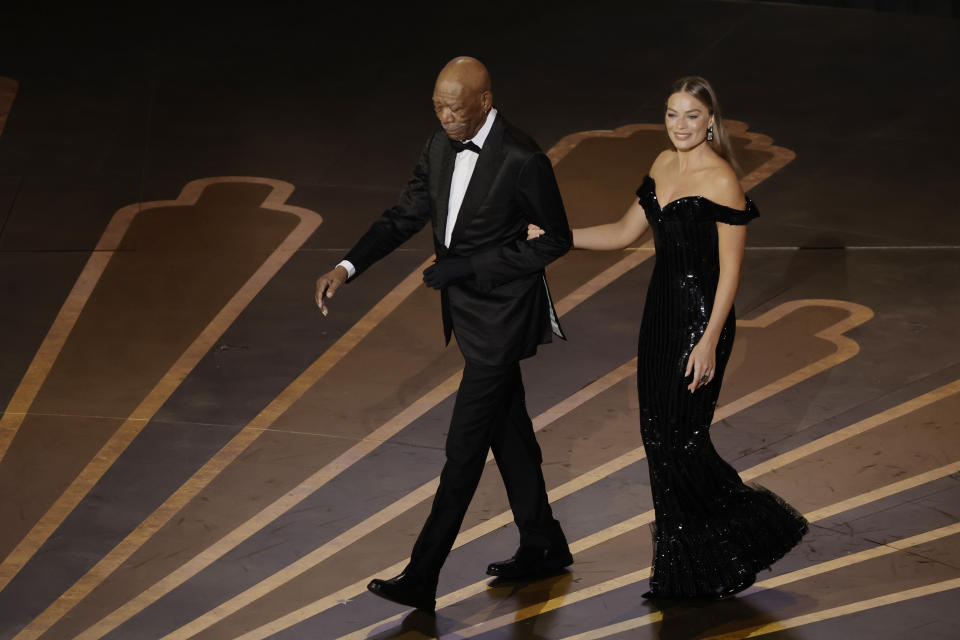 HOLLYWOOD, CALIFORNIA - MARCH 12: (L-R) Morgan Freeman and Margot Robbie walk onstage during the 95th Annual Academy Awards at Dolby Theatre on March 12, 2023 in Hollywood, California. (Photo by Kevin Winter/Getty Images)