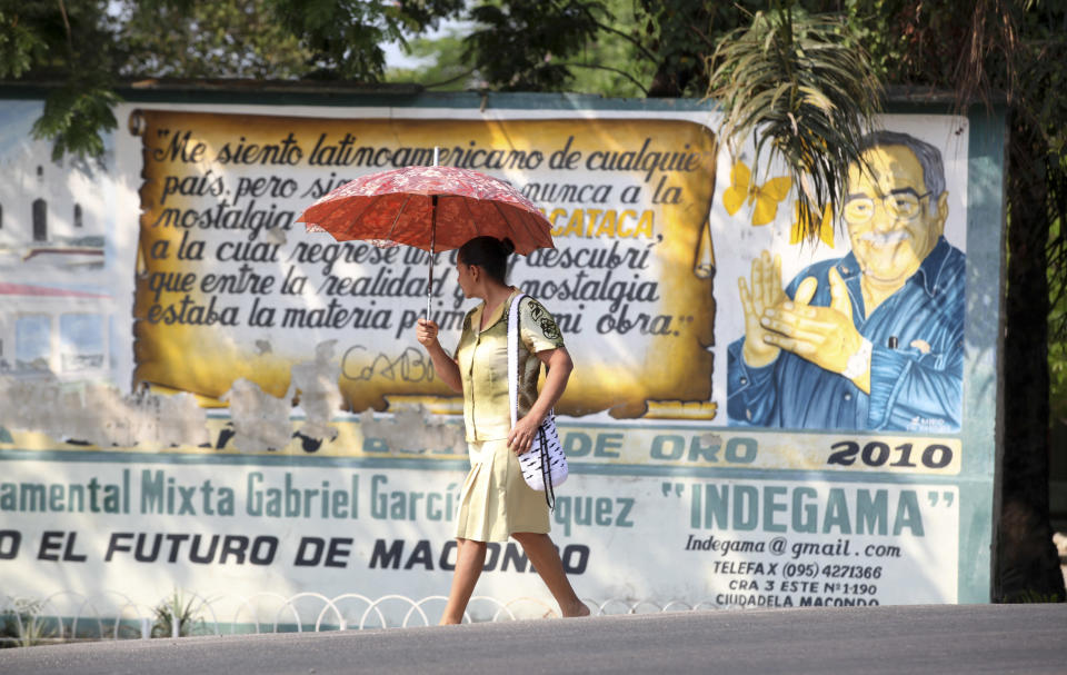 A woman walks past a mural of Nobel laureate Gabriel Garcia Marquez in Aracataca, the city were he was born in Colombia's Caribbean coast, Friday, April 18, 2014. Garcia Marquez died in Mexico City on April 17, 2014. (AP Photo/Ricardo Mazalan)