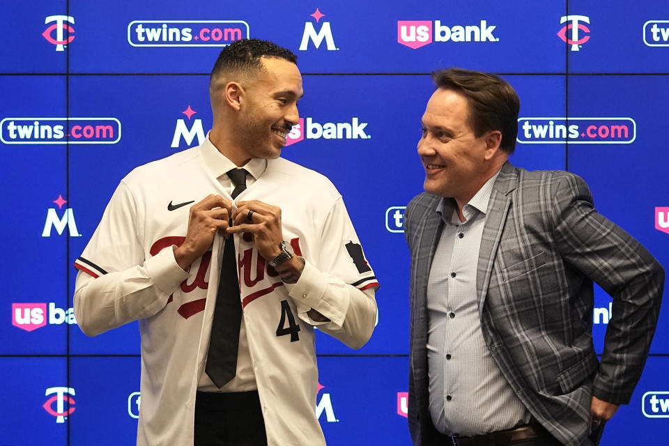 Minnesota Twins' Carlos Correa, left, puts on a team jersey alongside Twins president of baseball operations Derek Falvey at Target Field on Wednesday, Jan. 11, 2023, in Minneapolis. (AP Photo/Abbie Parr)