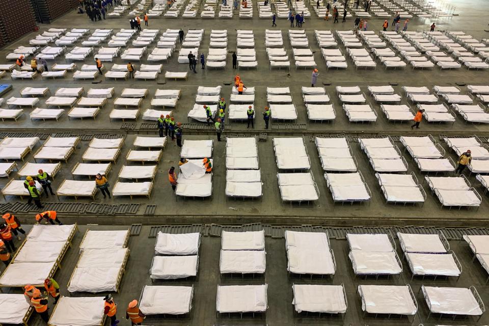 Workers set up beds at an exhibition centre that was converted into a hospital in Wuhan in China's central Hubei province on February 4, 2020. - The Wuhan government said it plans to convert three existing venues, including a gymnasium and an exhibition centre, into hospitals to take in patients with mild symptoms of the new coronavirus that has so far claimed more than 400 lives. (Photo by STR / AFP) / China OUT (Photo by STR/AFP via Getty Images)