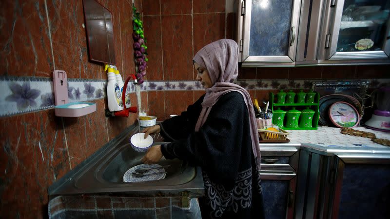 Jassem, 24, an Iraqi nurse wahes the dishes at home in Baghdad