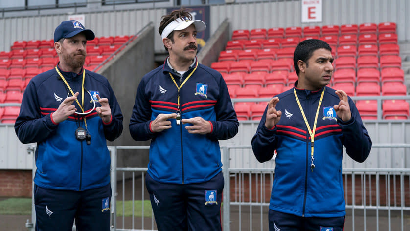 The Ted Lasso coaches stand on the sidelines