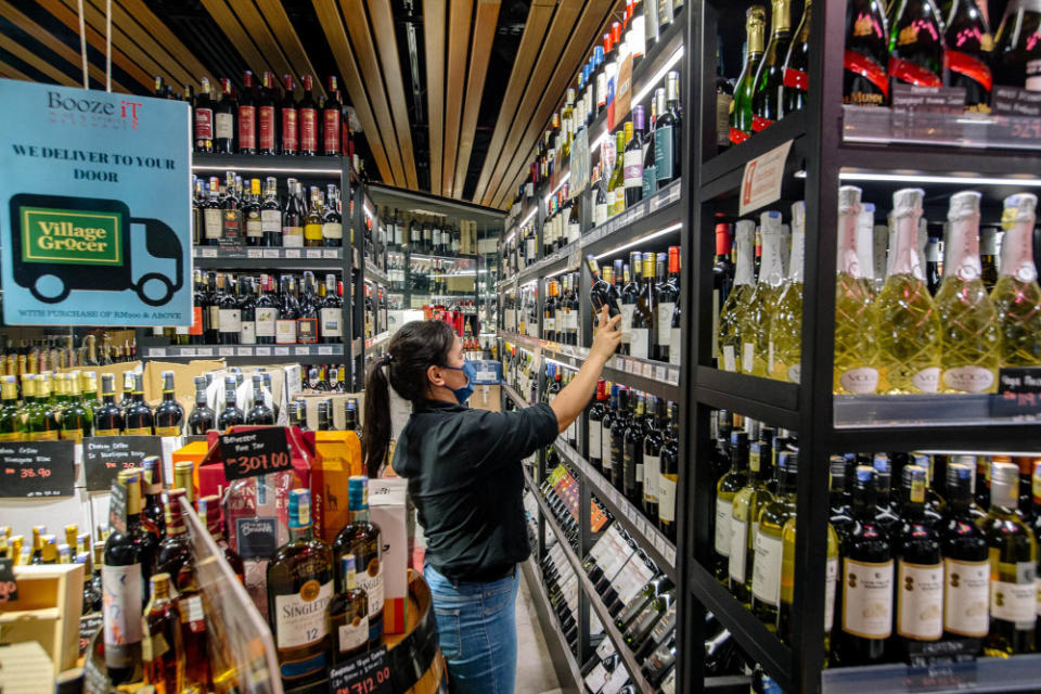 Staff arranging bottles of alcohol at Village Grocer in Bangsar, Kuala Lumpur, June 4, 2021. — Picture by Firdaus Latif