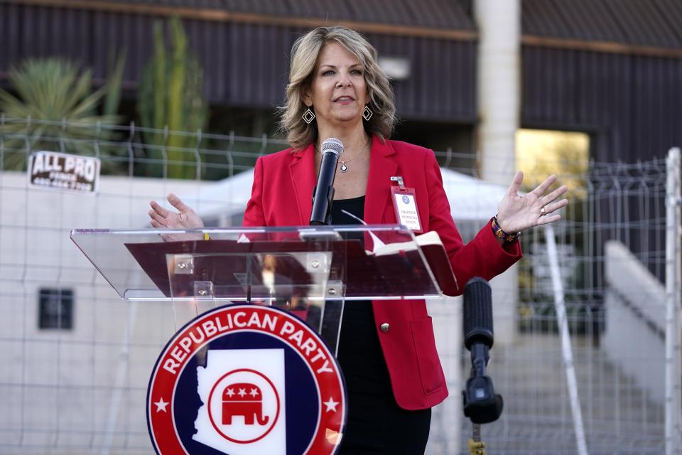 Kelli Ward, chair of the Arizona Republican Party, stands at a podium during an outdoor press conference. 