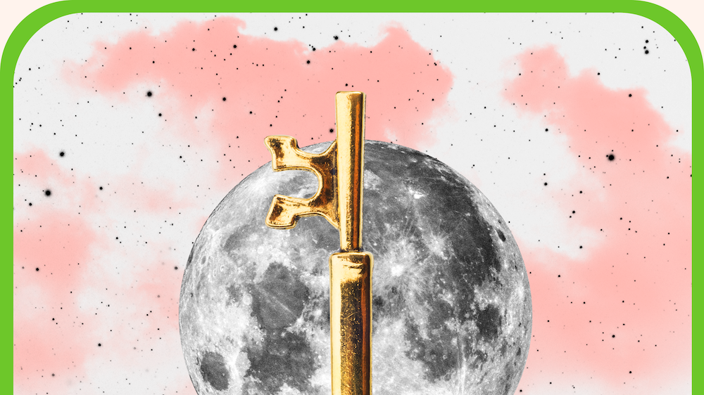 the ace of wands tarot card, showing a black and white hand holding up a golden key over a full moon