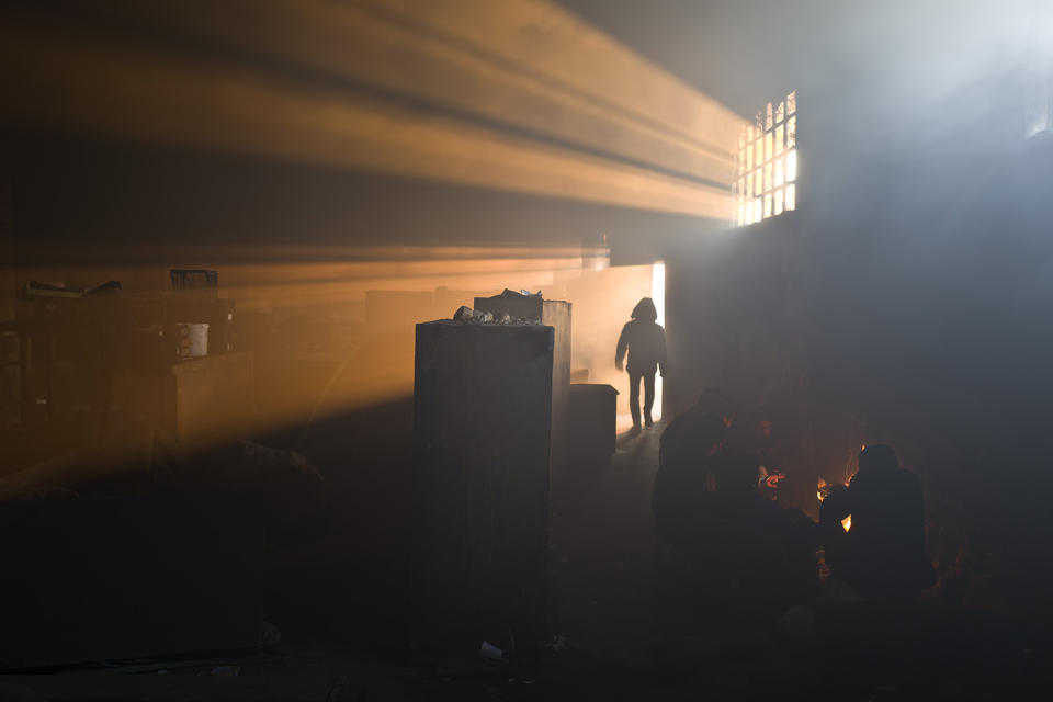 <p>A group of migrants warm themselves by a fire in an abandoned warehouse in Belgrade, Serbia, Jan. 30, 2017. Hundreds of migrants have been sleeping rough in freezing conditions in downtown Belgrade looking for ways to cross the heavily guarded EU borders. (Photo: Muhammed Muheisen/AP) </p>