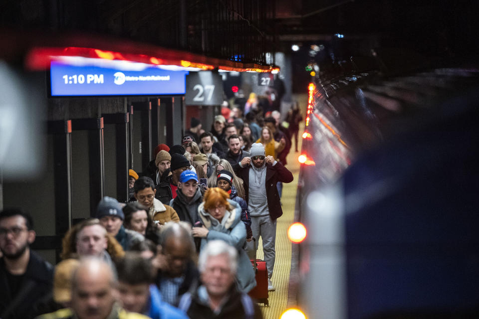 Travelers walk the ramp as they arrive to Grand Central Station in New York, Thursday, Dec. 21, 2023. (AP Photo/Eduardo Munoz Alvarez)
