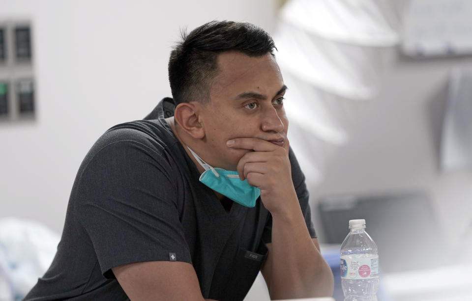 Medical student Diego Montelongo pauses after a patient died inside the Coronavirus Unit at United Memorial Medical Center, Monday, July 6, 2020, in Houston. Hospitalizations due to COVID-19 in the second-largest state in the U.S. have more than doubled in the last two weeks. (AP Photo/David J. Phillip)