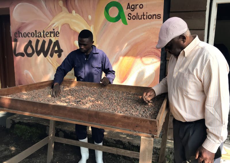 Lowa chocolate factory manager Kalinda Salumu Alexis and his employee dry cocoa pods at the Lowa Chocolate Factory in Goma