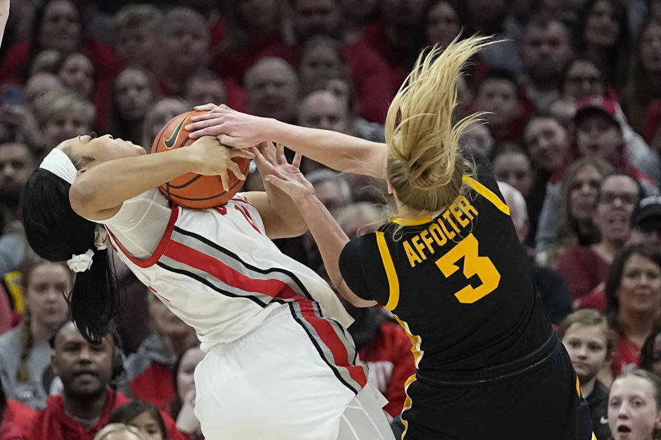 Ohio State forward Taiyier Parks, left, and Iowa guard Sydney Affolter (3) fight for control of the ball in the first half of an NCAA college basketball game Sunday, Jan. 21, 2024, in Columbus, Ohio. (AP Photo/Sue Ogrocki)