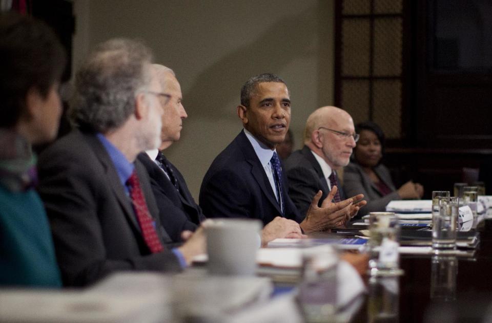 President Barack Obama speaks to media as he meets with, from left, White House Senior Adviser Valerie Jarrett, Robert Bauer, Co-Chair, Presidential Commission on Election Administration, Vice President Joe Biden, and Benjamin Ginsberg, Co-Chair, Presidential Commission on Election Administration, and other members of the Presidential Commission on Election Administration, Wednesday, Jan. 22, 2014, in the Roosevelt Room of the White House in Washington. The Commission was created to identify non-partisan ways to shorten lines at polling places, promote the efficient conduct of elections, and provide better access to the polls for all voters. (AP Photo/Carolyn Kaster)