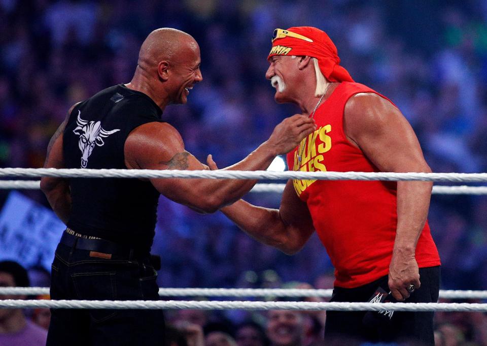 Dwayne Johnson aka The Rock, left, embraces Hulk Hogan during Wrestlemania XXX at the Mercedes-Benz Super Dome in New Orleans on Sunday, April 6, 2014. (Jonathan Bachman/AP Images for WWE)