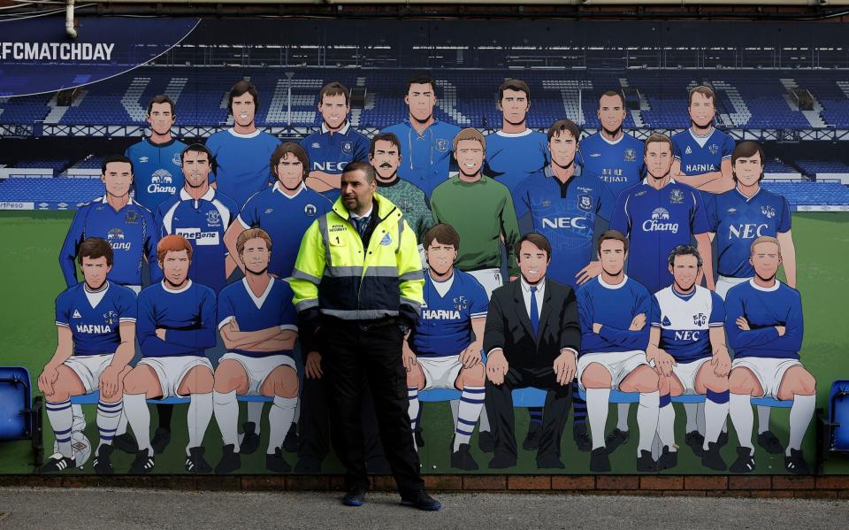 A steward stands in front of a team of Everton greats