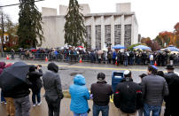 People line both sides of the street as they gather outside the Tree of Life Synagogue for a service on Saturday, Nov. 3, 2018, in Pittsburgh. About 100 people gathered in a cold drizzle for what was called a "healing service" outside the synagogue that was the scene of a mass shooting a week ago. (AP Photo/Keith Srakocic)