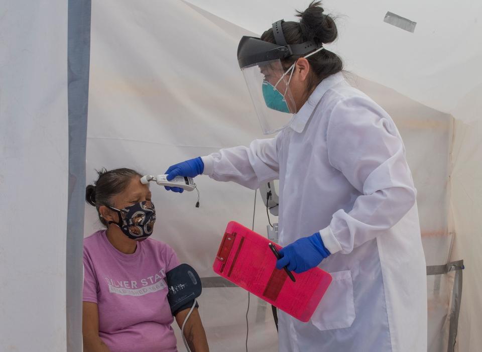 FILE: A nurse checks vitals from a Navajo Indian woman complaining of virus symptoms, at a COVID-19 testing center at the Navajo Nation town of Monument Valley in Arizona on May 21, 2020. / Credit: Photo by MARK RALSTON/AFP via Getty Images