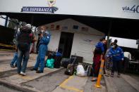 Venezuelan migrants line up to register at a migrant service point run by the International Rescue Committee (IRC) in Chusaca