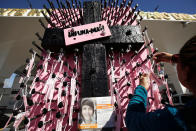 <p>A woman places names of missing girls at a memorial with a message that reads “Not One More,” marking women who have gone missing or have been found dead, during a protest to mark International Women’s Day at Paso del Norte international border crossing, in Ciudad Juarez, Mexico, March 7, 2018. (Photo: Jose Luis Gonzalez/Reuters) </p>