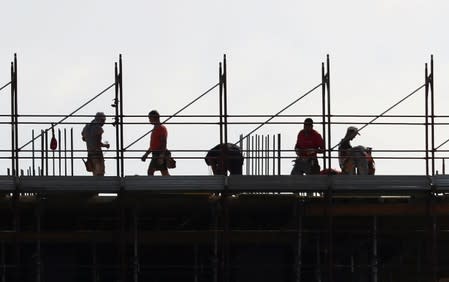 FILE PHOTO: People work at the construction site of a new residential building on the outskirts of Rome