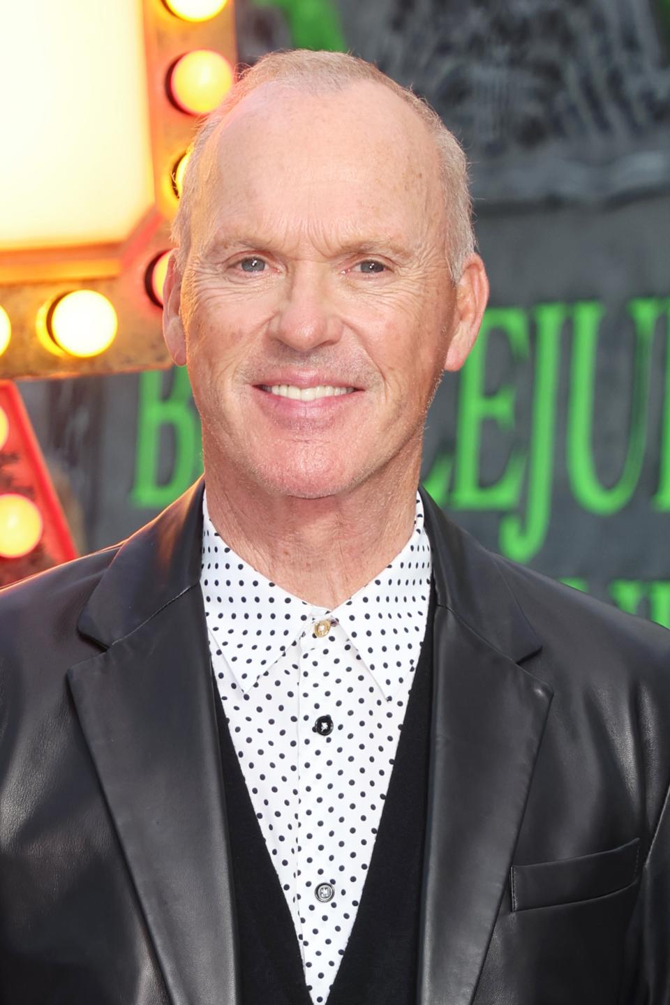 Michael Keaton wears a polka dot shirt with a black blazer at a red carpet event