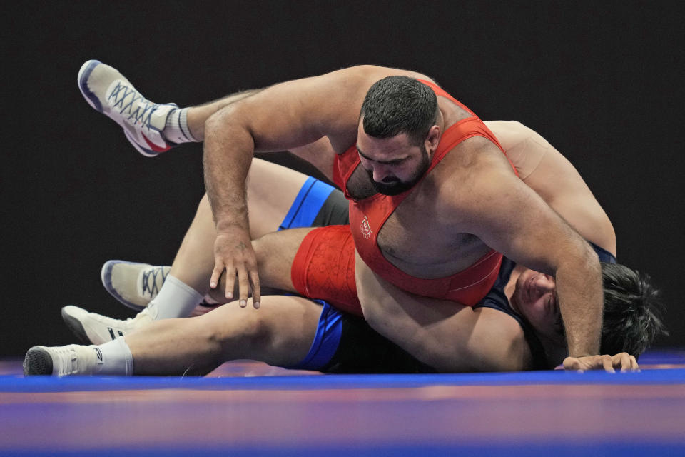 India's Naveen, red, and South Korea's Kim Minseok compete during their men's greco-roman 130kg wrestling bronze medal match at the 19th Asian Games in Hangzhou, China, Thursday, Oct. 5, 2023. (AP Photo/Aaron Favila)