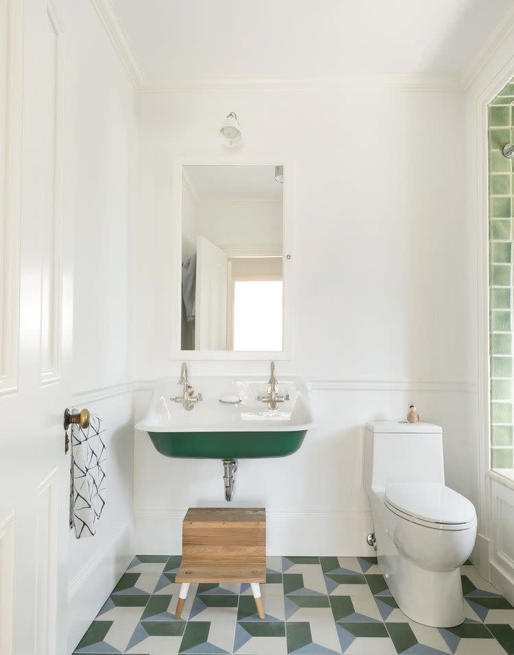 <p>When decorating a child's bathroom, opt for colors and motifs that are both youthful and timeless. In this bathroom designed by Studio DB, the neutral green colors and geometric tiles do the trick. Then add a fun step stool under the sink so the little ones can reach it (and to make the space feel more playful). </p>