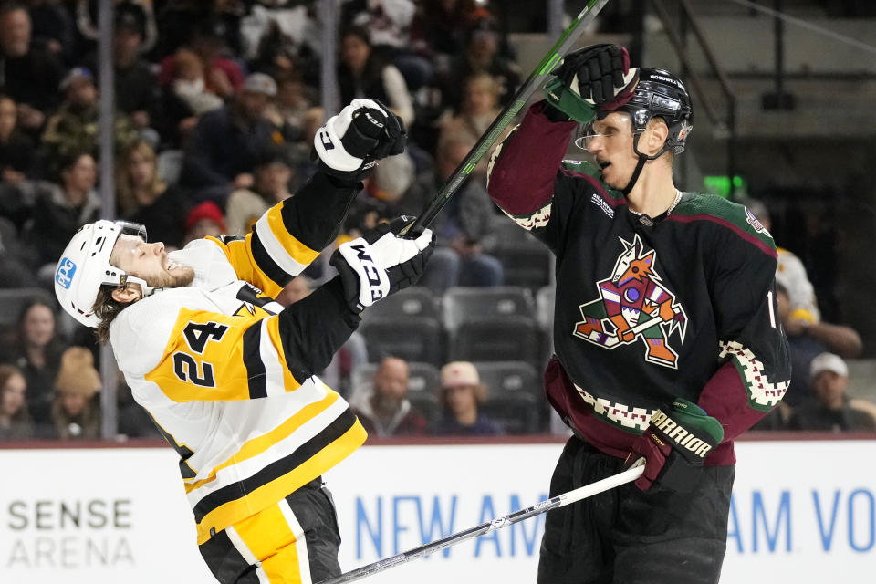 Arizona Coyotes center Nick Bjugstad, right, gives Pittsburgh Penguins defenseman Ty Smith (24) a shove to the face during the first period of an NHL hockey game in Tempe, Ariz., Sunday, Jan. 8, 2023. (AP Photo/Ross D. Franklin)