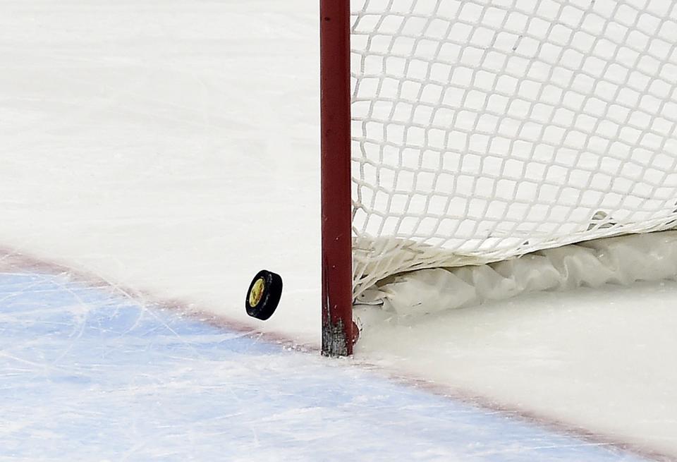 The puck hits the post with Canada's goalie pulled in the last minutes of the third period of the gold-medal women's hockey game between Canada and the United States at the Sochi Winter Olympics in Sochi, Russia, on Thursday, Feb. 20, 2014. Canada scored in the final minute of regulation, and won 3-2 in overtime. (AP Photo/The Canadian Press, Nathan Denette)