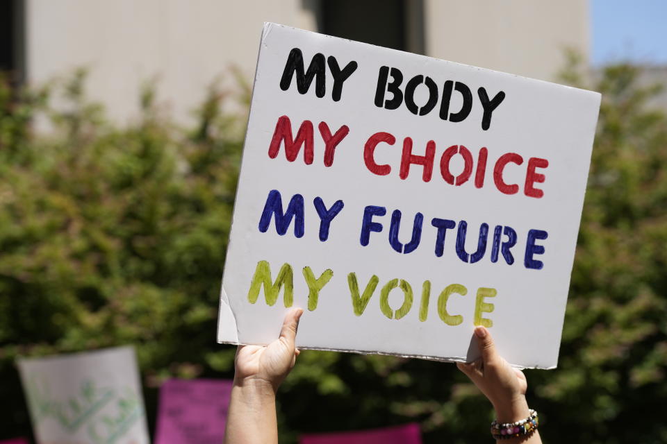 FILE - A woman supporting abortion-rights holds a sign outside the South Carolina Statehouse on July 7, 2022, in Columbia, S.C. A new poll from The Associated Press-NORC Center for Public Affairs Research shows an upheaval in priorities just months before critical midterm elections. (AP Photo/Meg Kinnard, File)