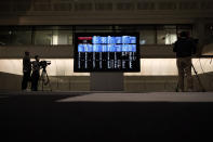 Members of media film the blank stock board at Tokyo Stock Exchange Thursday, Oct. 1, 2020, in Tokyo. The Tokyo Stock Exchange temporarily suspended all trading due to system problem. (AP Photo/Eugene Hoshiko)