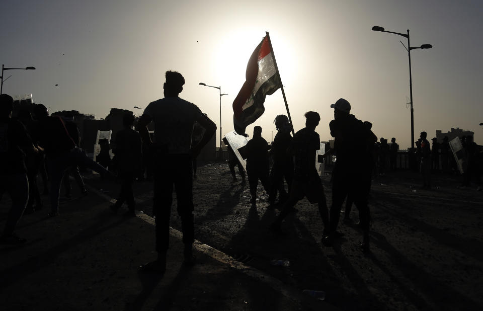 Anti-government protesters throw stones towards security forces during a demonstration in Tahrir Square in Baghdad, Iraq, Wednesday, Sept. 28, 2022. (AP Photo/Hadi Mizban)