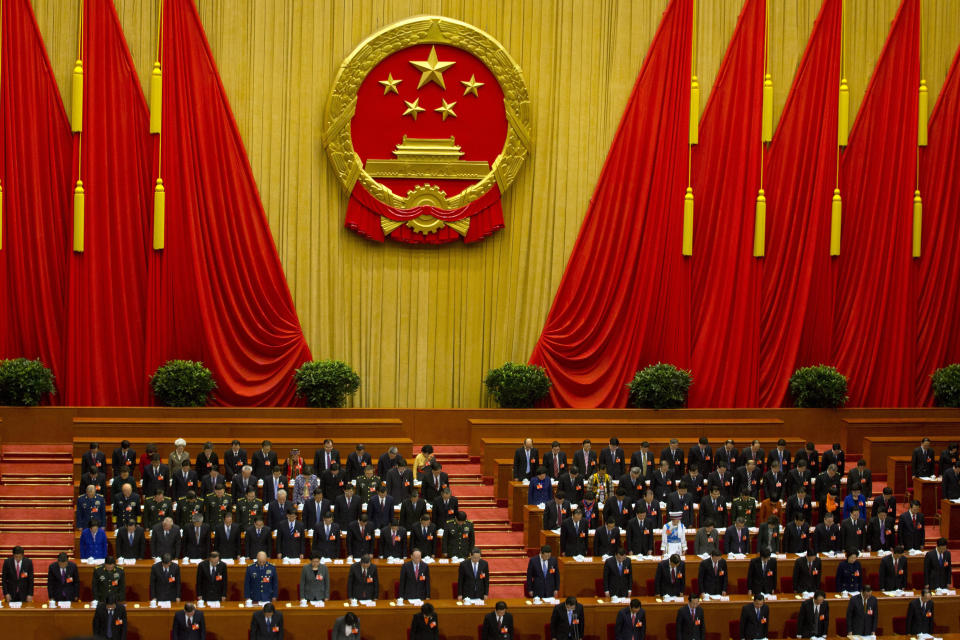 China's top leaders including Chinese President Xi Jinping, center, bow their heads to observe a minute of silence to commemorate the victims of the recent slashing incident in Kunming province during the opening session of the annual National People's Congress in Beijing's Great Hall of the People, China, Wednesday, March 5, 2014. (AP Photo/Ng Han Guan)