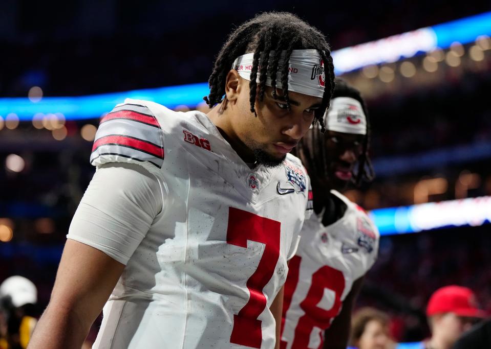 Dec 31, 2022; Atlanta, Georgia, USA; Ohio State Buckeyes quarterback C.J. Stroud (7) walks off the field after losing 42-41 to Georgia Bulldogs during the Peach Bowl in the College Football Playoff semifinal at Mercedes-Benz Stadium. 