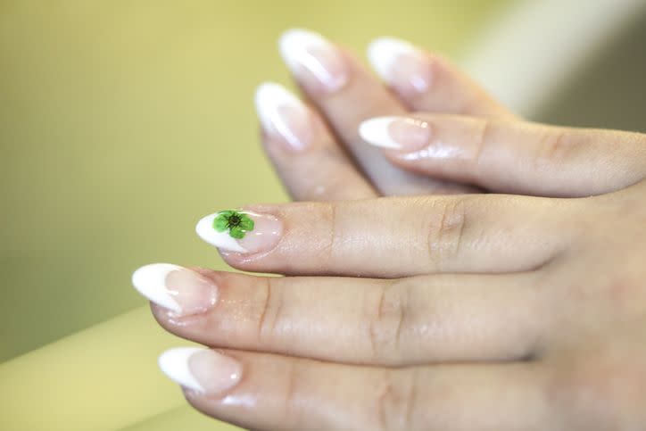 french manicure with a green flower on one nail
