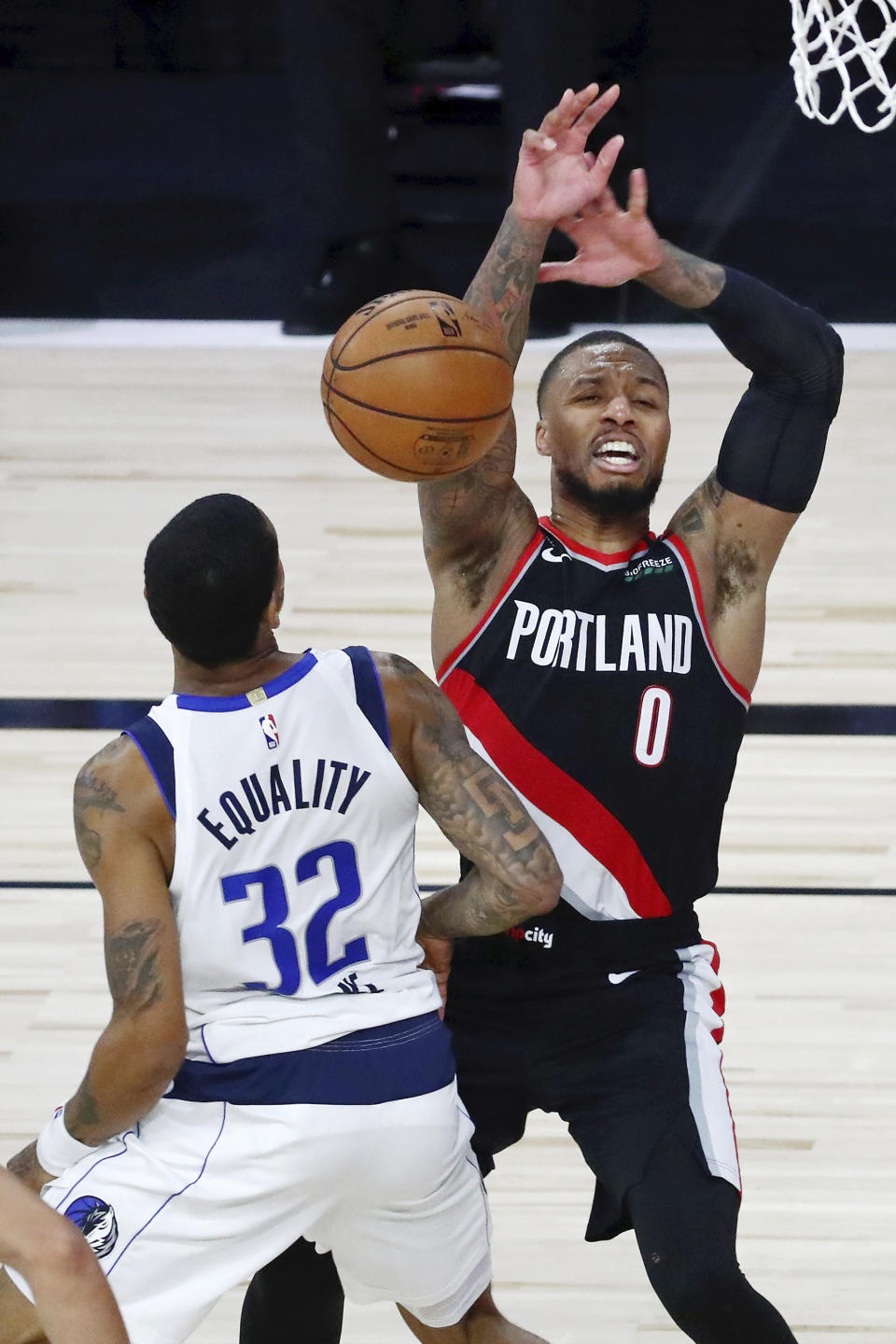 Dallas Mavericks guard Trey Burke (32) steals the ball from Portland Trail Blazers guard Damian Lillard (0) during the second half of an NBA basketball game Tuesday, Aug. 11, 2020, in Lake Buena Vista, Fla. (Kim Klement/Pool Photo via AP)