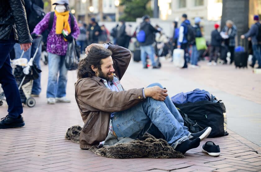 SAN FRANCISCO, CA - DECEMBER 17, 2022 - Drug user Rich McHugh smokes after falling down at UN Plaza in San Francisco, California on December 17, 2022. Dozens of people consume fentanyl, meth and other illegal substances in public near the site of a recently closed safe consumption site. (Josh Edelson/for the Times)