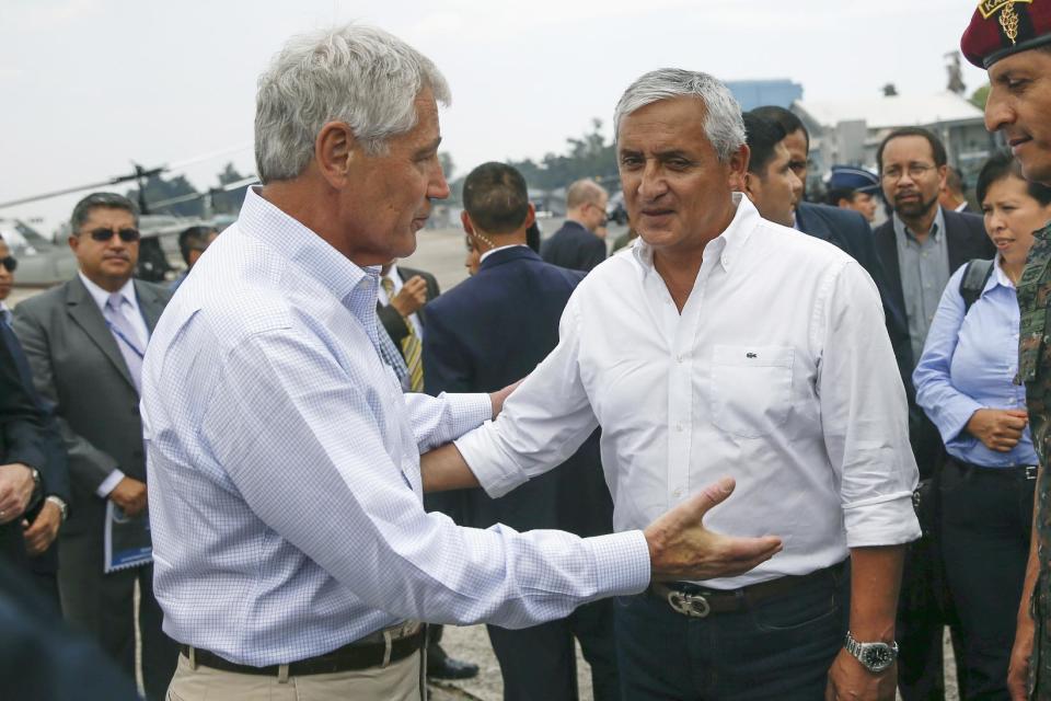 Defense Secretary Chuck Hagel and Guatemalan President Otto Perez Molina embrace before his departure from Guatemala City, Guatemala, Friday, April 25, 2014. (AP Photo/Shannon Stapleton, Pool)