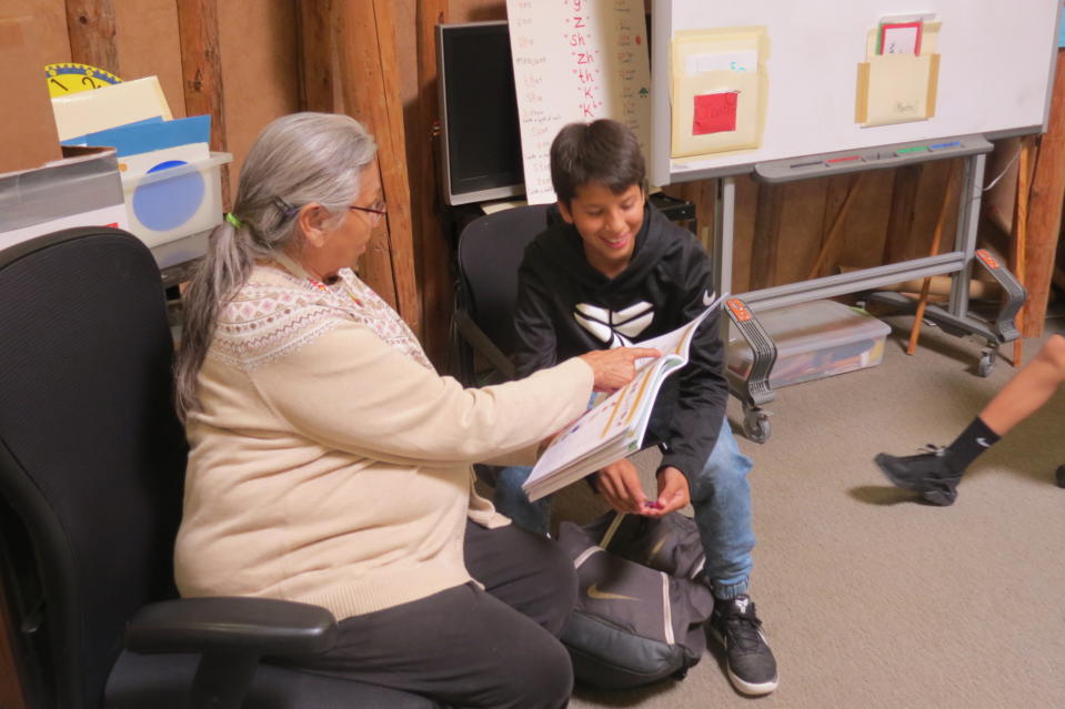 Wagoⁿze Phillips (left) teaching a student the Umonhon language with textbooks.