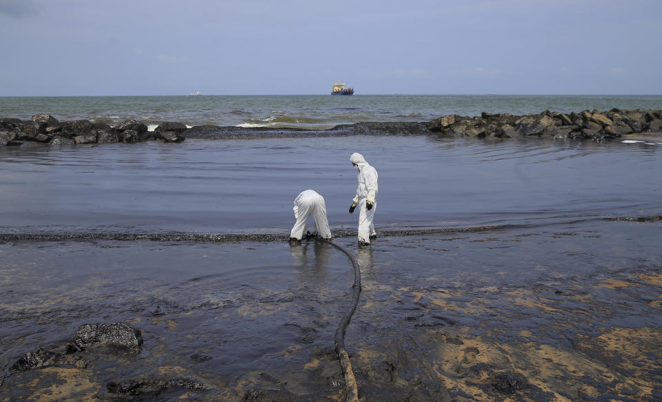 Sri Lankan coast guard personnel in protective clothes work to remove oil from a beach following an oil spill in Uswetakeiyawa, a coastal town north of Colombo, Sri Lanka, Monday, Sept. 10, 2019.Sri Lanka deployed hundreds of coast guard and navy personnel on Monday to clean oil slicks on a coastal stretch near the capital following a spill caused by a pipeline leak. (AP Photo/Eranga Jayawardena)